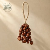 Handmade deep reddish-brown seed wind chime hanging, handheld natural chime