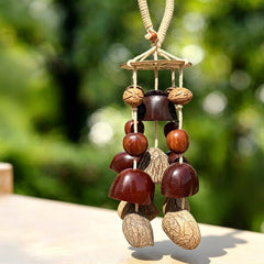 Forest canopy seed wind chime with blue beads, dark polished pod bells and ivory nuts on a white background