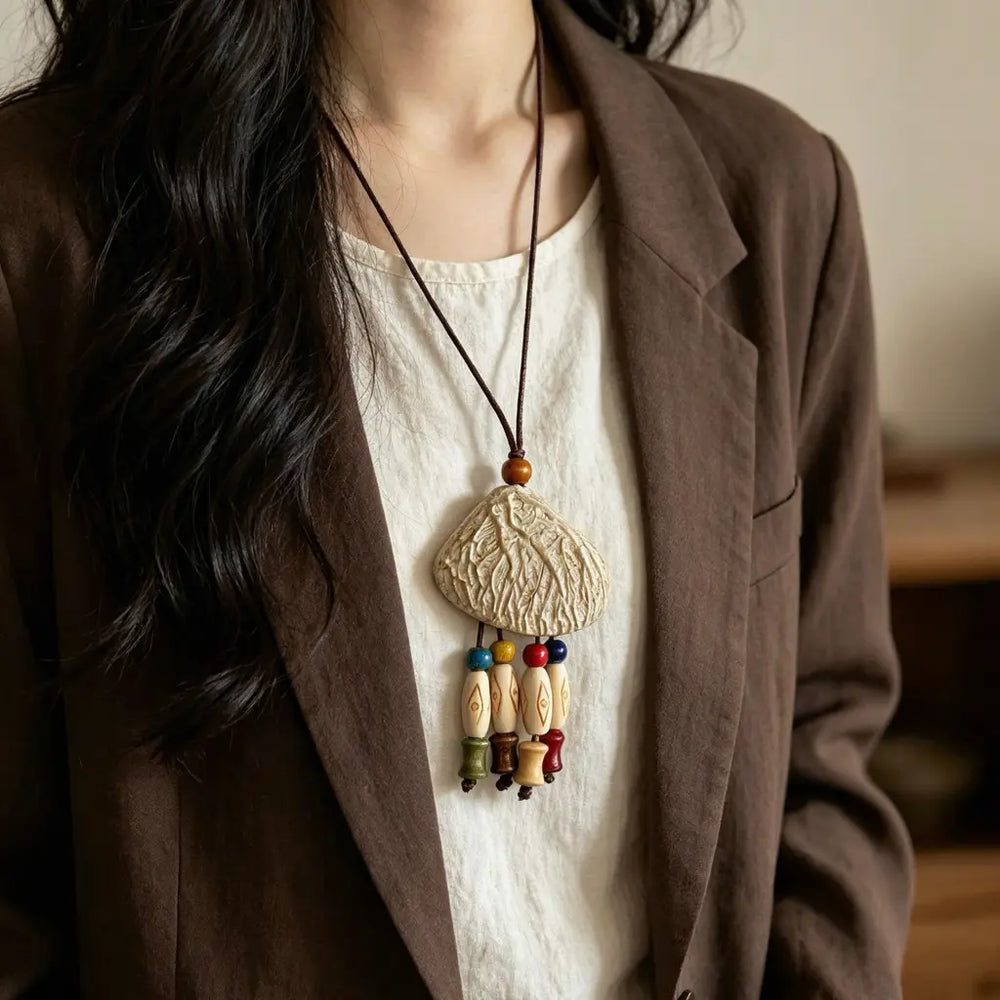 Shell Mosaic natural seed necklace — triangular shell-and-cowrie mosaic pendant with green stones, handmade boho pendant on adjustable cord
