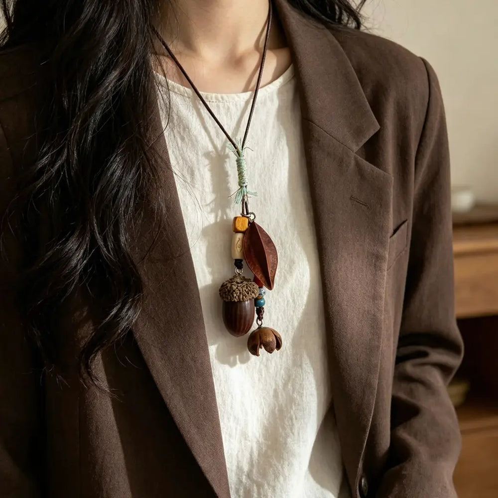 Festival Wrap natural seed necklace — colorful thread-wrapped cord with black and red bead cluster, handmade boho pendant on adjustable cord