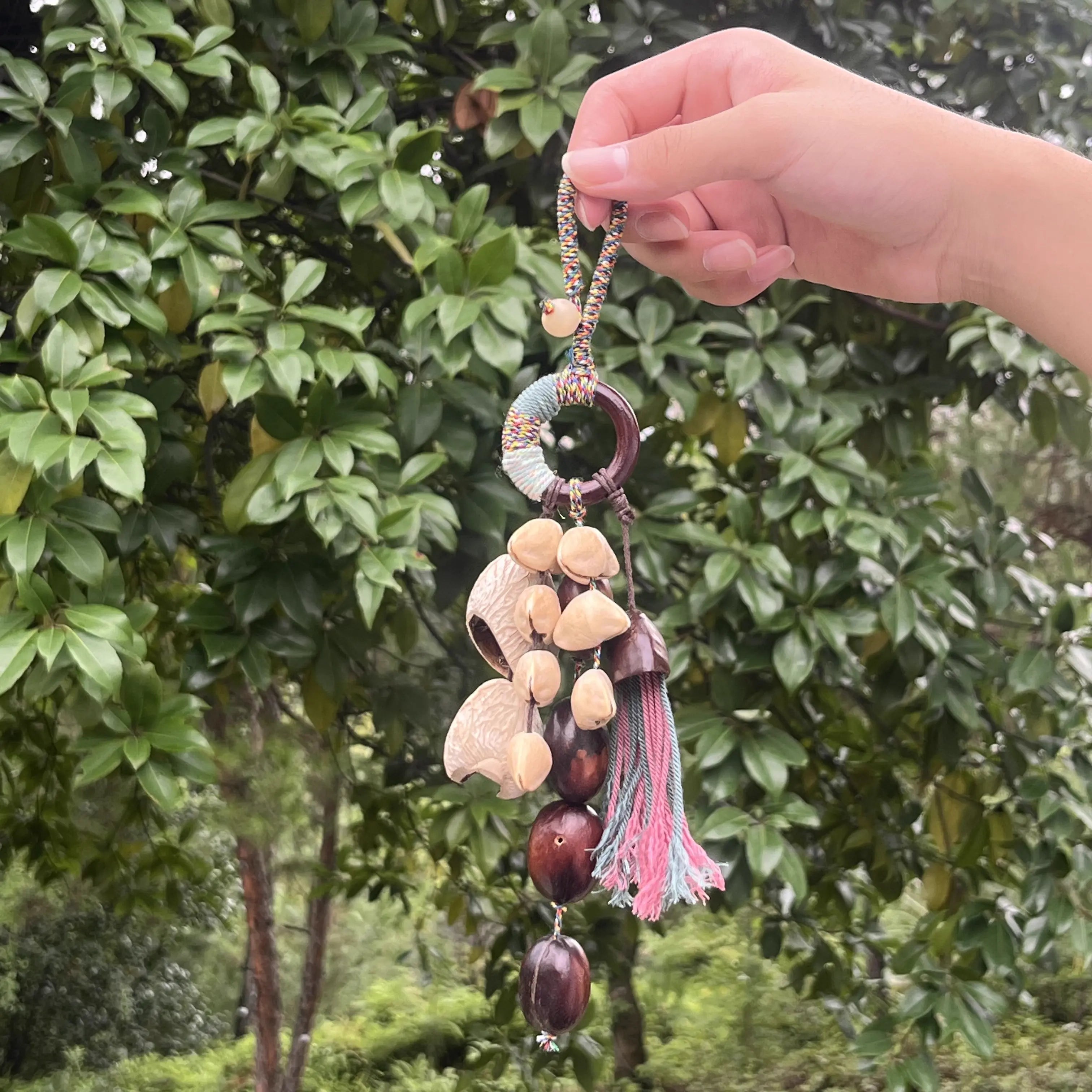 Handmade Boho Tassel bag charm with pink and blue tassels, multicolor braided cord, and natural seed shells