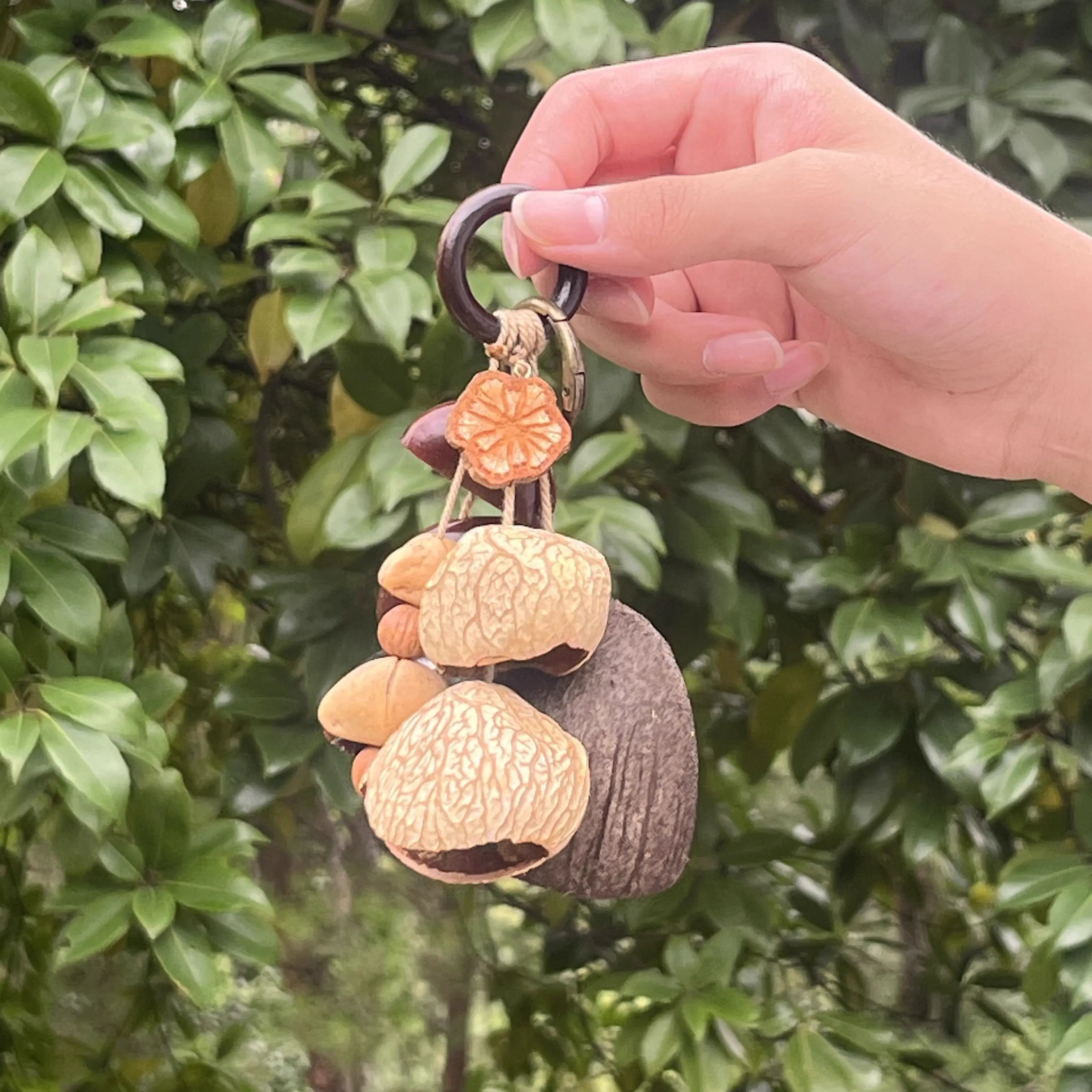 Handmade Forest Spirit bag charm with brass clasp, cream and dark brown natural shells, carved orange accent on wooden ring