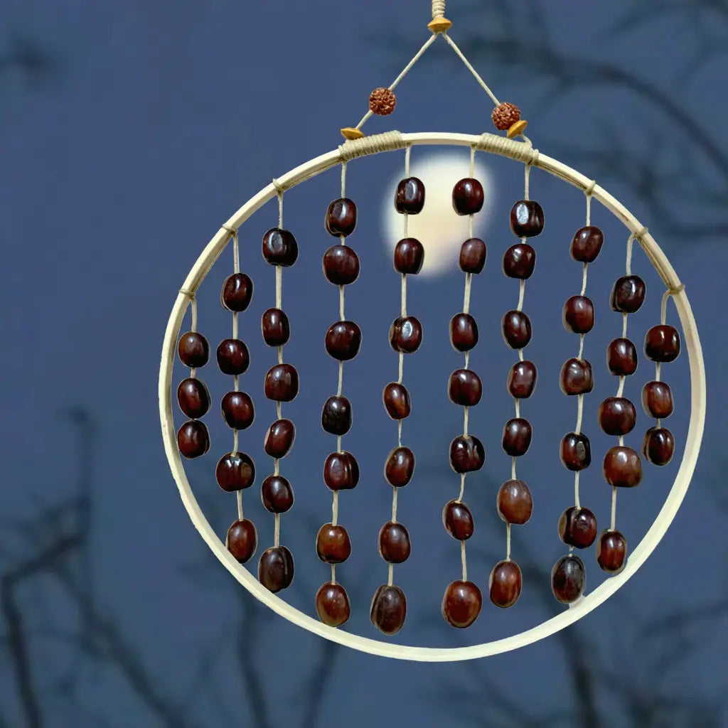 Midnight Disc fruit shell wind chime with dense dark seed pods on a ring