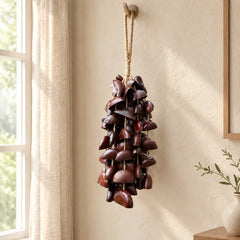 Handmade juju entada bass seed chime hanging by a bright window in soft daylight