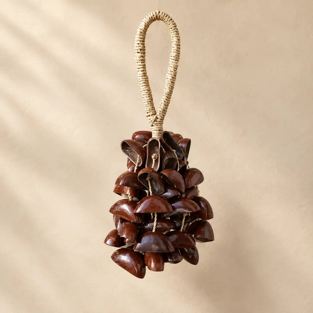 Handmade Juju seed pod rattle with 56 polished dark brown half-shells (14 per strand, four clusters) on a wrapped fiber loop handle, deep grounding shaker sound for meditation