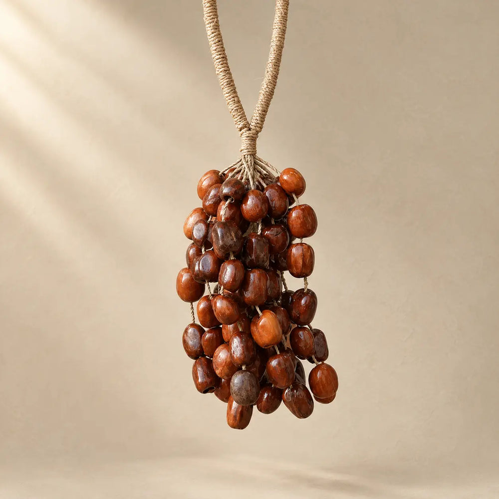 Handmade Pala seed hanging chime with 98 polished reddish-brown seeds clustered on natural fiber rope, warm boho sound decor