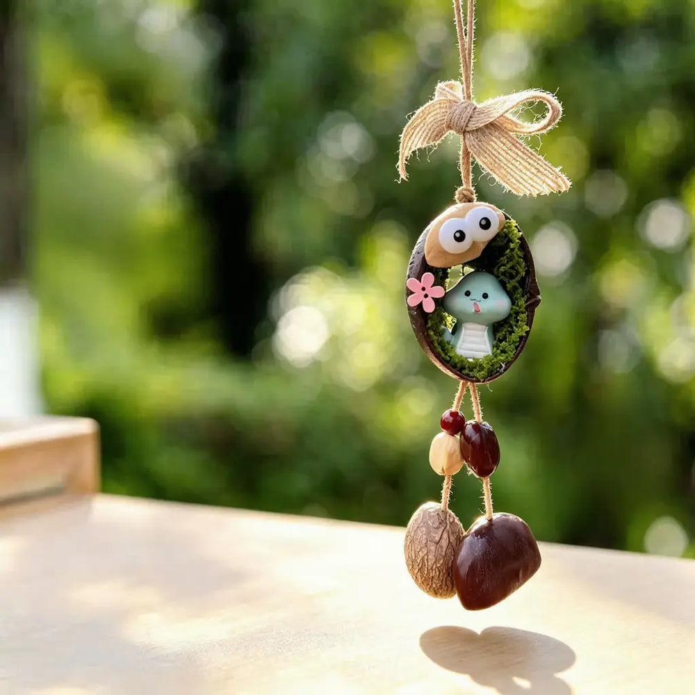 Snake zodiac chime — cute light blue snake in a mossy nut shell nest with googly eyes and seed bells
